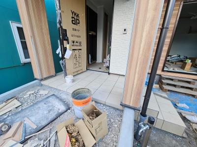 ポーチ：玄関ポーチでタイル工事が進んでいます。